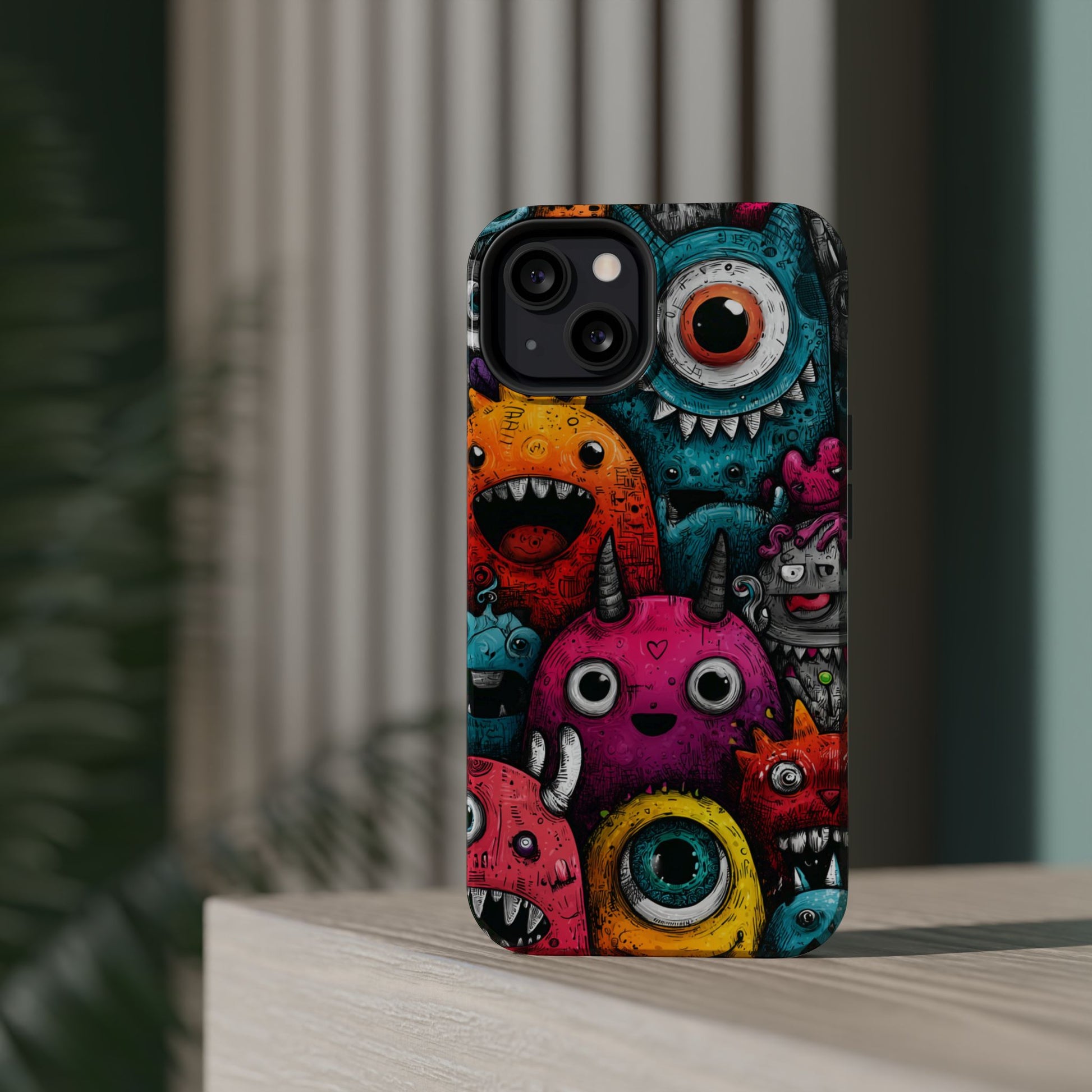 Bold pink and blue phone case featuring quirky monsters